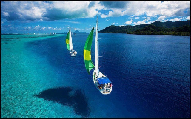 dos veleros navegando por aguas cristalinas
